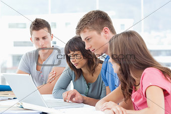 A group all looking into the laptop