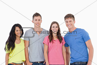 Four people standing beside one another and smiling 
