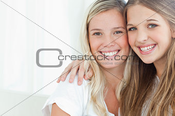 A smiling pair of sisters looking at the camera