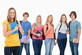 A group of college students standing as one girl stands in front