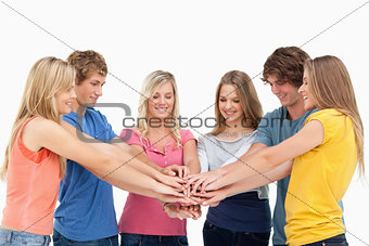 Friends standing around each other as they stack their hands and