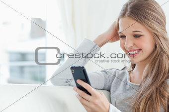 A smiling girl looking at her mobile phone
