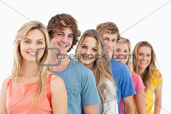 A smiling group standing behind each other 