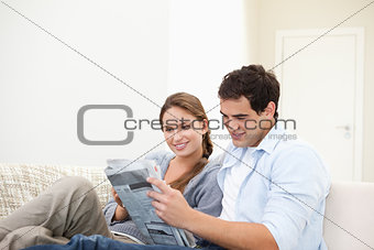 Couple lying while reading a newspaper