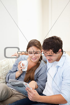 Couple hugging while reading a newspaper