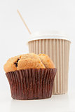 Muffin and a cup of coffee placed together