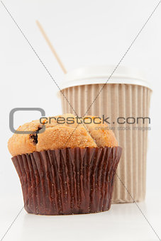 Muffin and a cup of coffee placed together