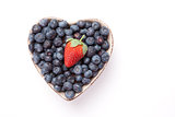 Blueberries and one Strawberry  in  a heart shaped bowl