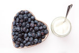 White yogurt and blueberries in a heart shaped bowl 