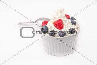 Jar of berries and whipped cream with spoon