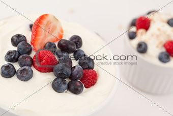 Bowl of cream with different berries 