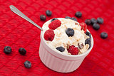 Pot of berries and whipped cream with spoon 