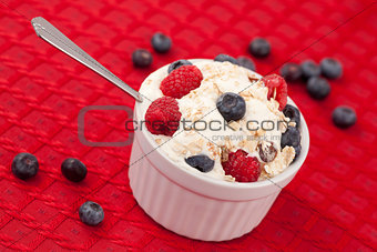 Pot of berries and whipped cream with spoon 