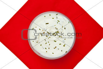 Bowl of dip with herbs on a red napkin