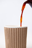 Paper cup being filled with coffee