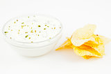 Bowl of a white dip with herbs and chips 