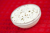Bowl of white dip on a red tablecloth