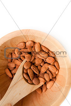 Wooden spoon with almonds in a bowl