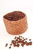 Close up of a basket full of coffee seeds with seeds lying in fr