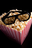 3D glasses lying on the top of a box of popcorn
