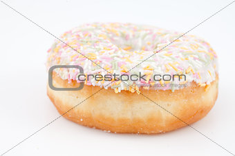 Close up of a doughnut with multi coloured icing sugar