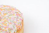 Close up of a doughnut with multi coloured icing sugar