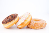 Three doughnuts with icing sugar lined up