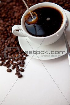 Milk being poured in a cup of coffee