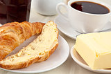 Breakfast with a croissant spread with butter