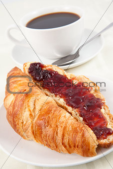 Coffee cup behind a croissant