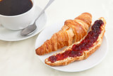 Croissant next to a coffee cup