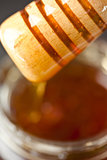 Honey dipper on top of a honey jar