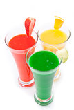 Three glasses full of fruit juice with fruits pieces