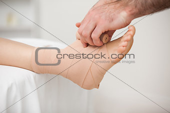 Practitioner bandaging an ankle