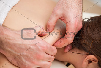 Back of woman being squeezed by hands of doctor