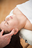 Woman lying on the back while being massaged on her head