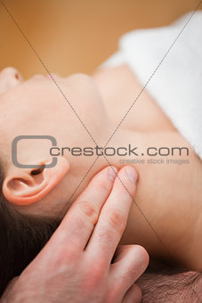 Close-up of doctor pressing two fingers on the neck of his patie