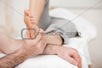 Woman having a foot massage while bending a leg