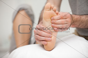 Chiropodist palpating the sole of the foot of a patient
