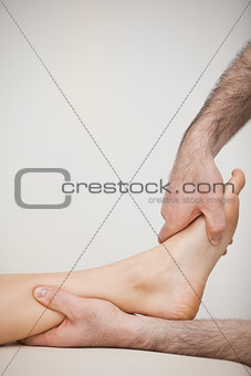 Side view of a foot being touched by a doctor