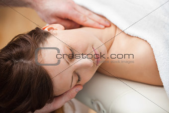 Doctor holding the head of a woman while massaging her neck