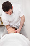 Therapist manipulating the neck of his patient while standing