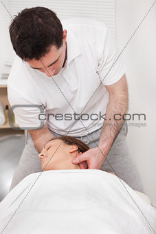 Therapist manipulating the neck of his patient while standing