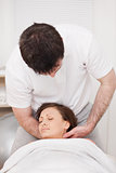 Therapist massaging the neck of a woman while holding her head