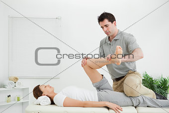 Chiropractor stretching the leg of his patient while holding it
