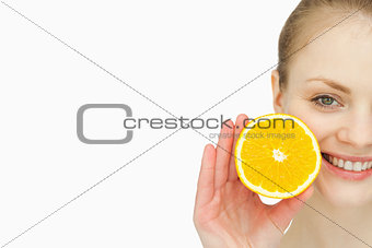Close up of a woman holding an orange in her hand