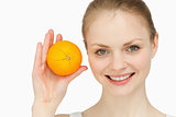 Joyful blonde-haired presenting an orange