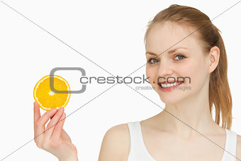 Cheerful woman holding an orange slice