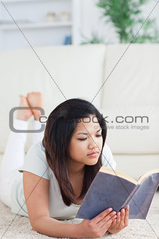 Woman lying on the floor reading a book