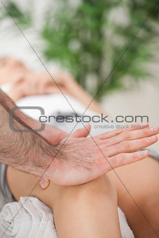 Osteopath using his hand palm to massage a knee
